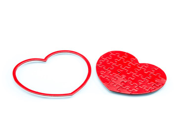 Red puzzle heart on white background, love concept