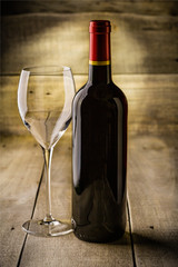 Fototapeta na wymiar Bottle of dry red wine with a glass