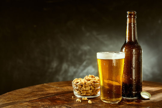 Beer and peanuts on an old wooden bar table