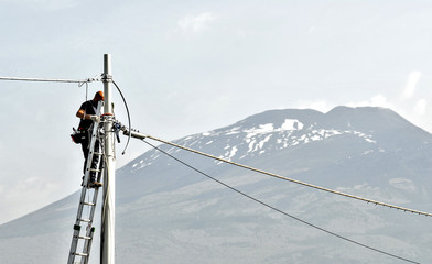 elettricista uomo al lavoro, su scala con palo e cavi