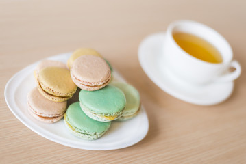  French colorful macaroons sweet dessert and with a cup of tea.