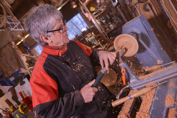 Woodturners using a rotating clamp to turn the wood.