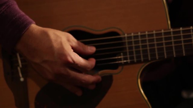 A man playing a guitar - close up