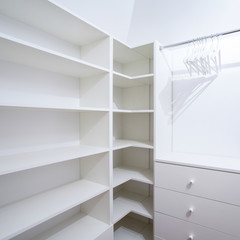 Interior of empty wardrobe with white furniture