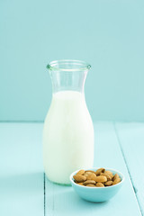 Fresh homemade almond milk in a bottle with fresh almonds