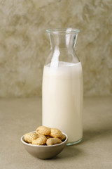 Fresh homemade peanut milk in a bottle with fresh peanuts