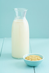 Fresh homemade oat milk in a bottle with oats