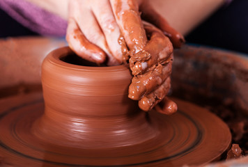 potter at the potter's wheel spins pottery