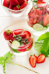 Detox. Fresh lemonade with strawberries, cucumber and mint on white wooden table
