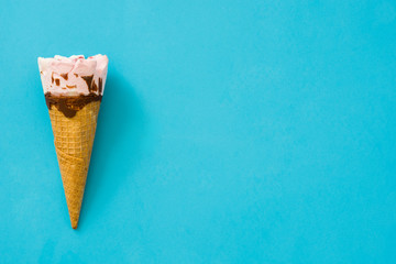 Strawberry ice cream cone on blue background
