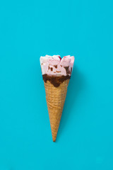 Strawberry ice cream cone on blue background
