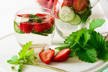 Detox. Fresh lemonade with strawberries, cucumber and mint on white wooden table