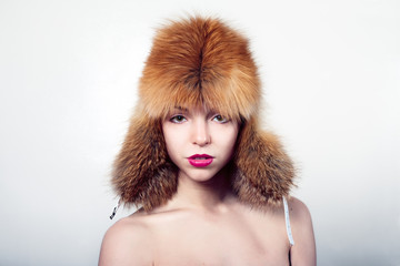 Head shot woman with big fur hat/
Head shot of young woman with huge fur hat. Clean and nice make-up pink/purple lip-stick.
