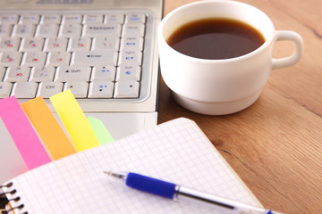 Office table with blank notepad and laptop 