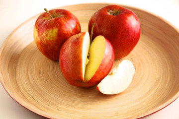 Fototapeta na wymiar Red apples on a wooden plate on the table