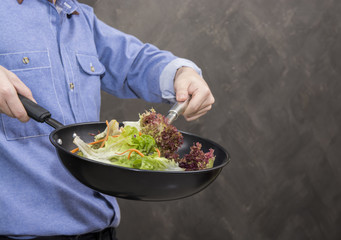 Young man cooking healthy food in the kitchen.