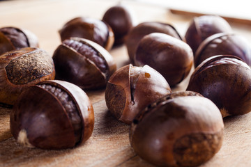 Chestnuts on wooden cutting board from side