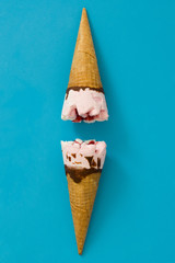 Strawberry ice cream cone on blue background
