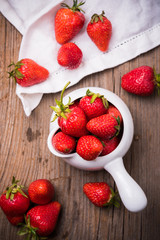 red organic strawberries in white bowl 