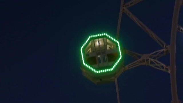 Close-up of Noria by rotating at night with large colorful of led lights and motion.Normal speed.
