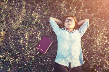 Young hipster woman lying in flower field after she tired for re