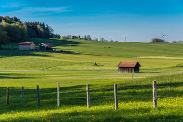 Weidezaun mit Heustadel und bl&uuml;henden Feldern im Fr&uuml;hling