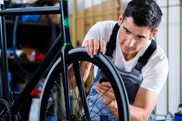 Mechanic repairing bicycle in his workshop
