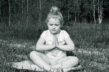 little girl meditating on the field