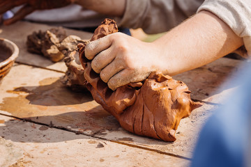 man hands working red clay to create handcraft art