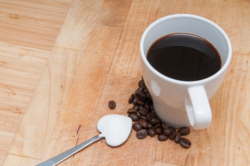 Coffee cup with sugar on a heart shaped spoon
