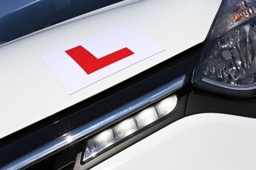 magnetic British L-plate affixed to the front of a white car