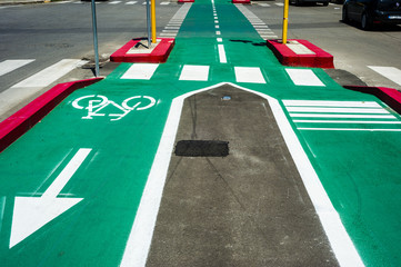 Bike lane city. Sign for bicycle painted on the asphalt colored. Car and traffic in background. Dividing line, diminishing perspective.