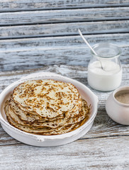 Crepes on a light wooden background. Delicious breakfast or snack