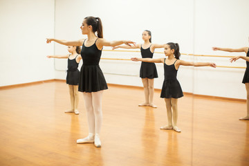 Naklejka premium Girls imitating teacher in a dance class