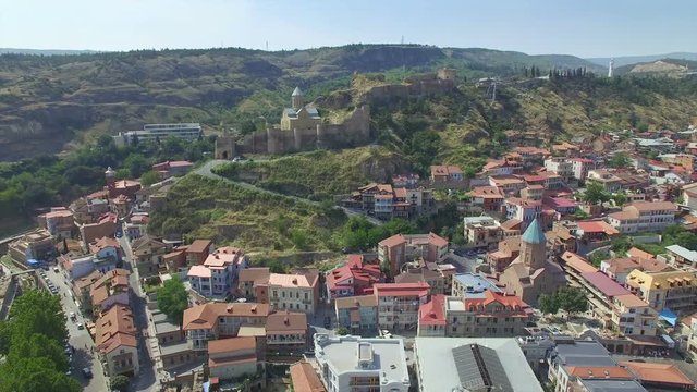 Aerial view of old town of Tbilisi, Narikala fortress. Camera flies on drone above city.