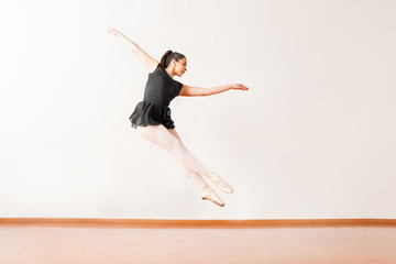 Pretty ballerina jumping in a dance studio