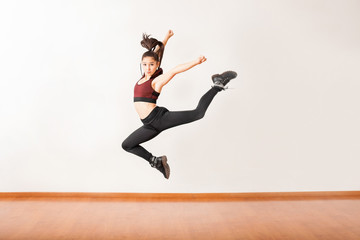 Young jazz dancer jumping in a studio