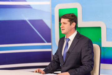 Male anchorman in tv studio. Live broadcasting
