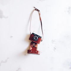 Vintage film camera hanging on grunge white wall