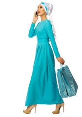 Muslim woman with mobile phone and bags