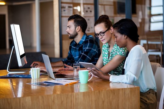 Business people sitting at computer desk 