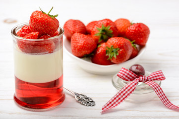Milk dessert - panna cotta with strawberry jelly and strawberries.