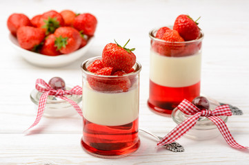 Milk dessert - panna cotta with strawberry jelly and strawberries.