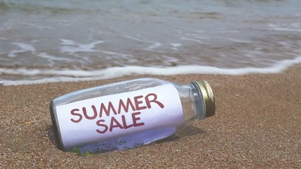 summer sale concept written in a bottle washed ashore