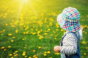 Little boy in hat standing on the field