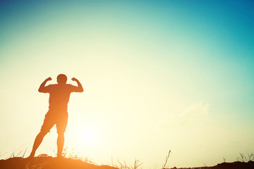 Silhouette of strong man with sunrise.