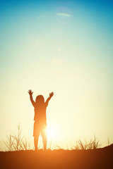 silhouette of girl raise her hands with sunset.