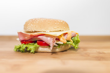 Panino con mortadella,formaggio, pomodoro e insalata su tagliere di legno