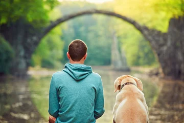 Foto auf Acrylglas Rakotzbrücke Nachdenklicher Mann, der mit seinem Hund sitzt