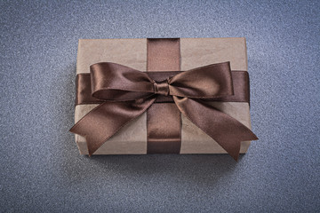 Boxed present in brown shop paper on grey background top view ce